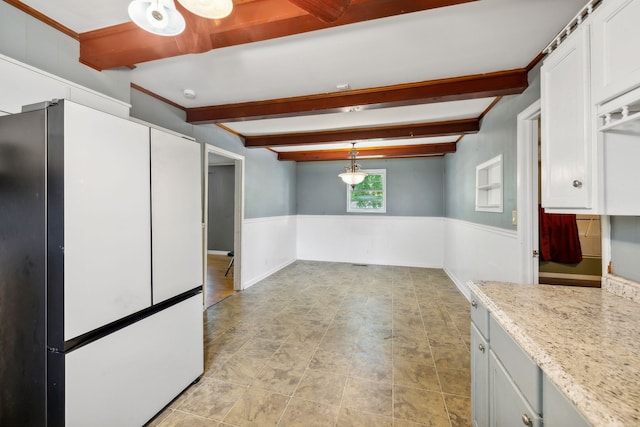 kitchen with white fridge, hanging light fixtures, beamed ceiling, and white cabinetry