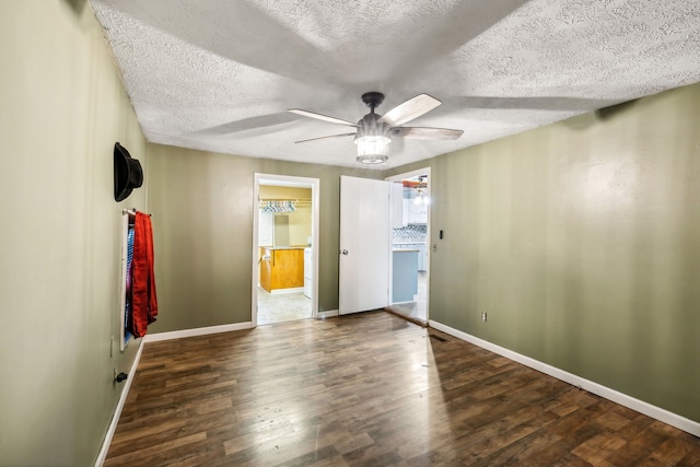 unfurnished room featuring dark hardwood / wood-style flooring, ceiling fan, and a textured ceiling