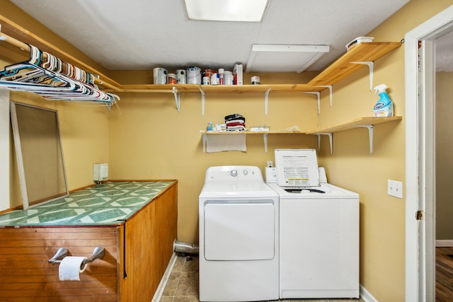 laundry room featuring washing machine and dryer and light tile patterned floors