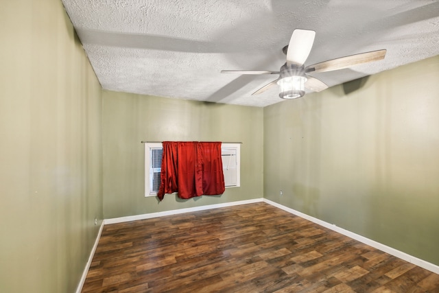 spare room with dark wood-type flooring, a textured ceiling, and ceiling fan