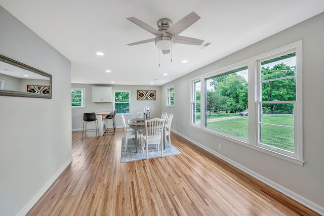 dining space with ceiling fan and light wood-type flooring