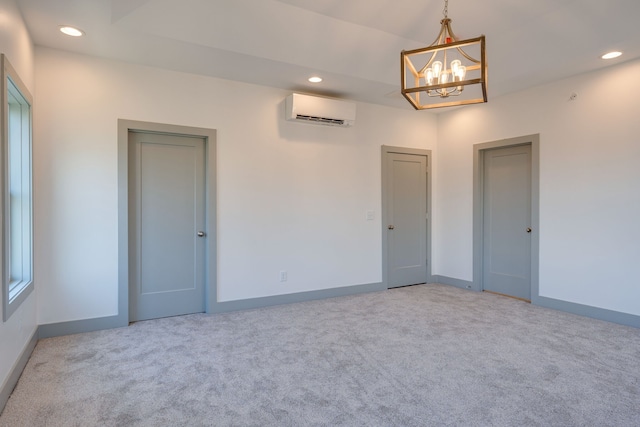 carpeted spare room with a wall unit AC and a notable chandelier