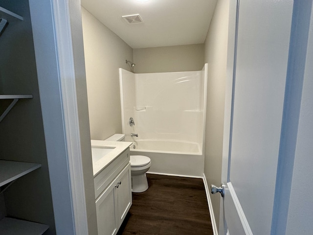 full bathroom featuring vanity, toilet, hardwood / wood-style floors, and washtub / shower combination