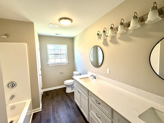 full bathroom featuring vanity, toilet, wood-type flooring, and washtub / shower combination