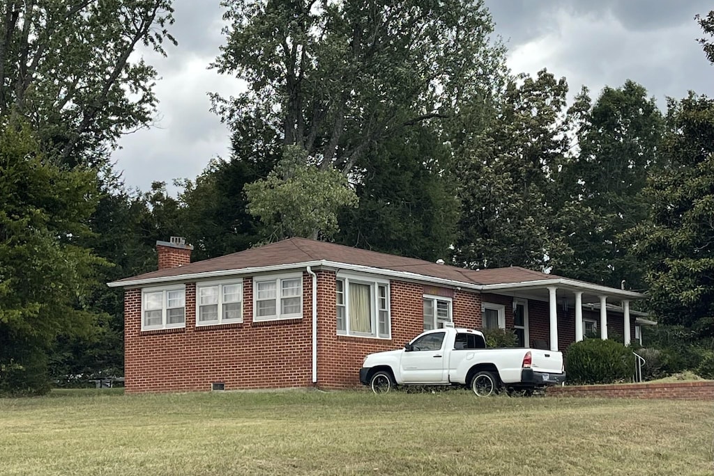 105 Northgate Dr, Mcminnville, TN 37110 - view of front facade featuring a front lawn, a chimney, brick siding, and crawl space
