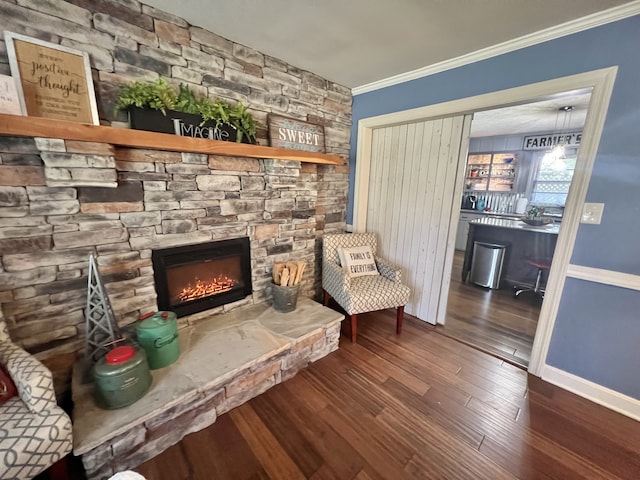 living area with crown molding, dark hardwood / wood-style flooring, and a fireplace