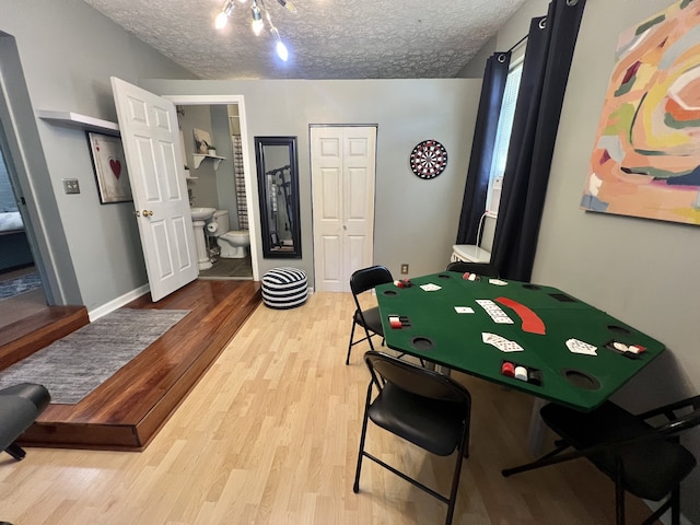 playroom with a textured ceiling and light hardwood / wood-style flooring