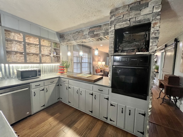 kitchen featuring a textured ceiling, hanging light fixtures, dark hardwood / wood-style floors, appliances with stainless steel finishes, and white cabinets