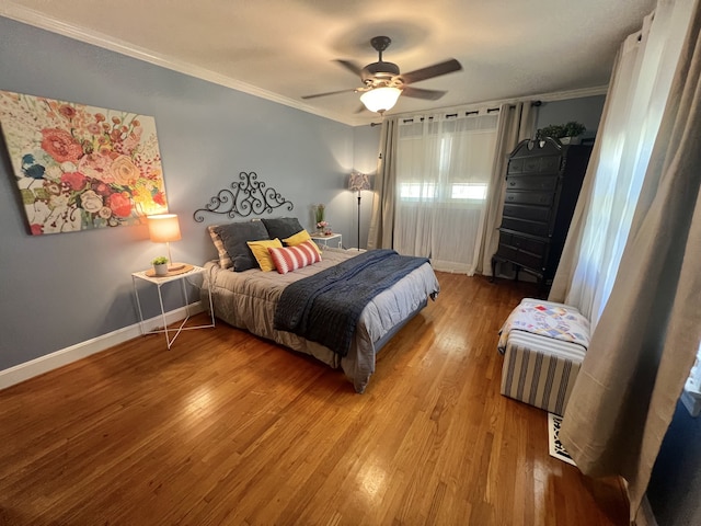 bedroom with crown molding, hardwood / wood-style flooring, and ceiling fan