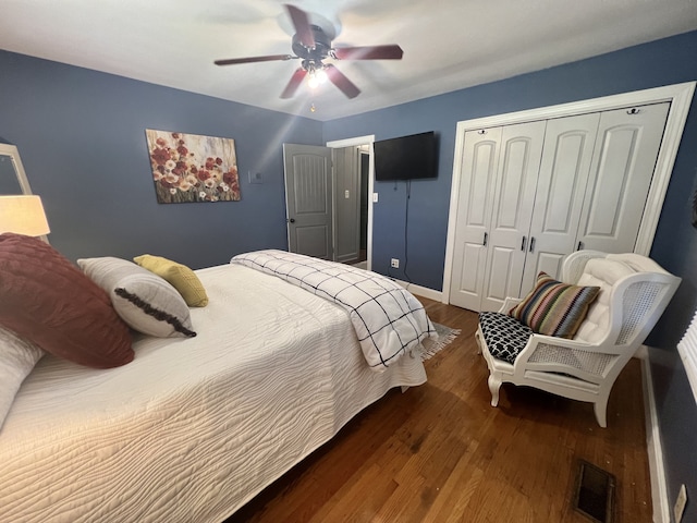 bedroom with dark wood-type flooring, a closet, and ceiling fan