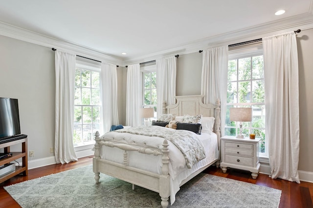 bedroom featuring multiple windows, dark hardwood / wood-style floors, and ornamental molding