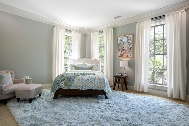 bedroom featuring carpet flooring, ornamental molding, and multiple windows