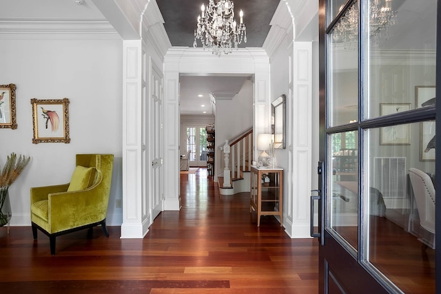 hall with dark wood-type flooring, ornamental molding, french doors, and a chandelier