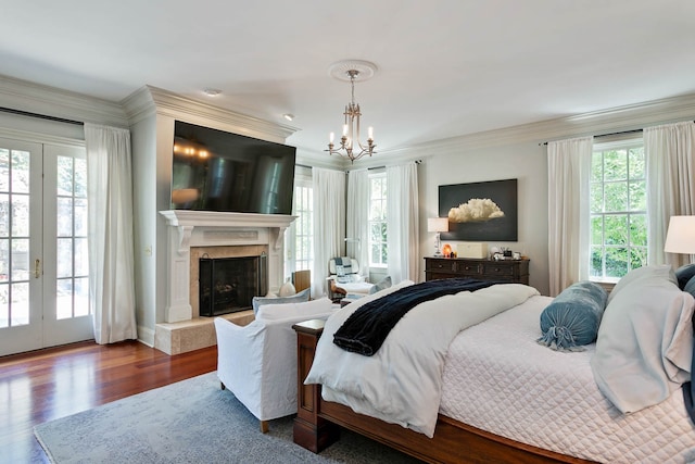 bedroom featuring crown molding, a chandelier, a premium fireplace, wood-type flooring, and access to exterior