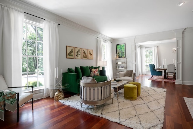 living area with ornamental molding, hardwood / wood-style flooring, and ornate columns