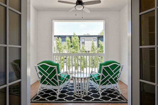 living area featuring tile patterned flooring and ceiling fan