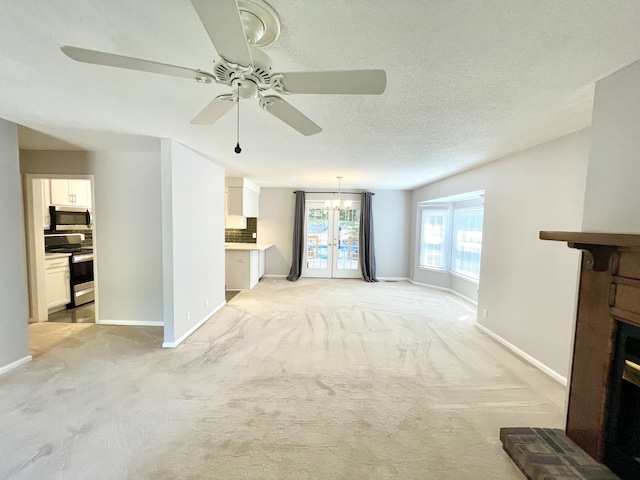 unfurnished living room with a textured ceiling, ceiling fan, and light carpet