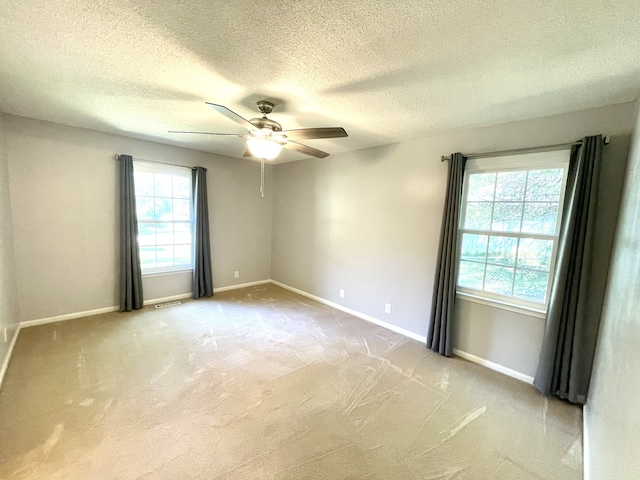 carpeted empty room featuring a textured ceiling and ceiling fan