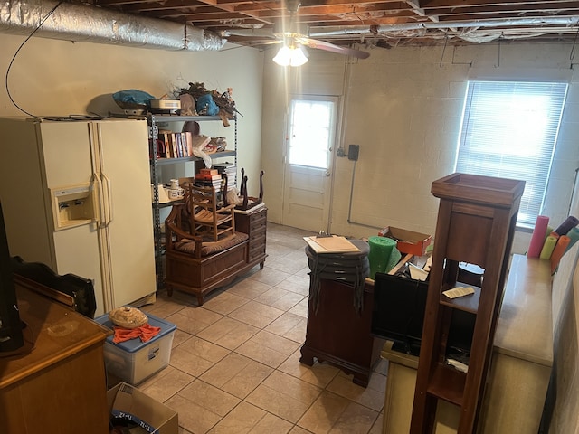 interior space featuring light tile patterned floors, ceiling fan, and white refrigerator with ice dispenser