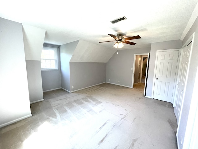 additional living space featuring vaulted ceiling, a textured ceiling, and ceiling fan