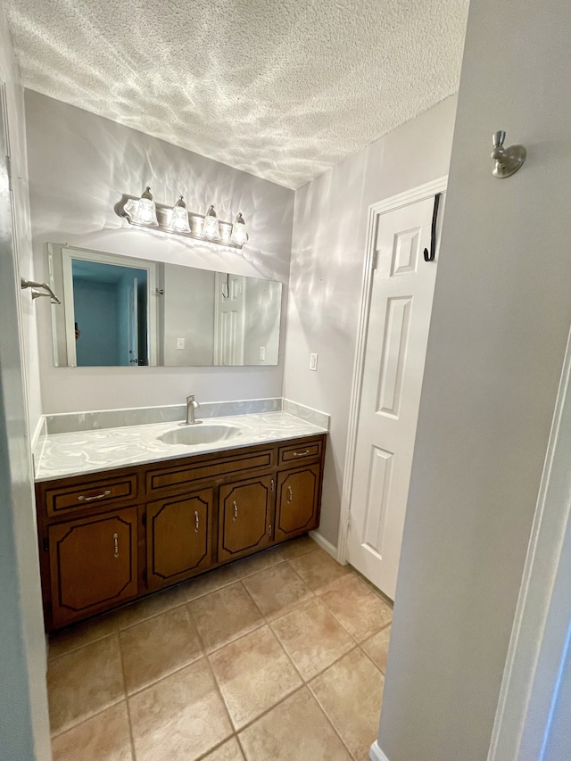 bathroom with tile patterned flooring, vanity, and a textured ceiling