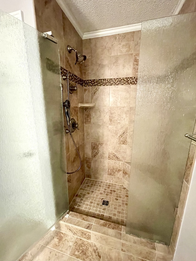 bathroom featuring ornamental molding, a textured ceiling, and a tile shower