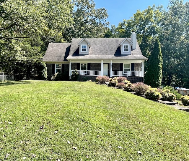 cape cod house with covered porch and a front yard