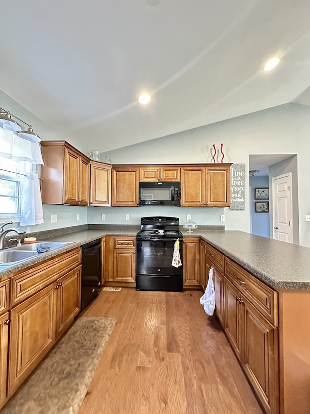 kitchen with black appliances, wood-type flooring, kitchen peninsula, sink, and lofted ceiling