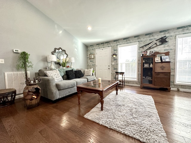 living room featuring a wealth of natural light, dark wood-type flooring, and lofted ceiling