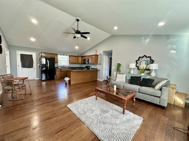 living room featuring lofted ceiling, dark wood-type flooring, ceiling fan, and sink