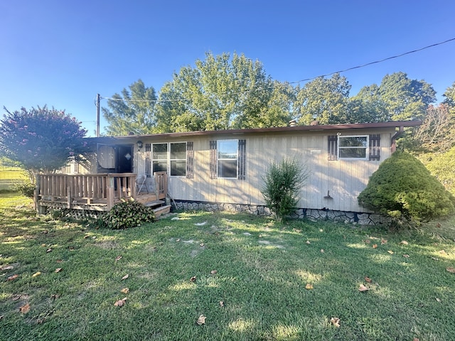 view of front of house with a deck and a front lawn