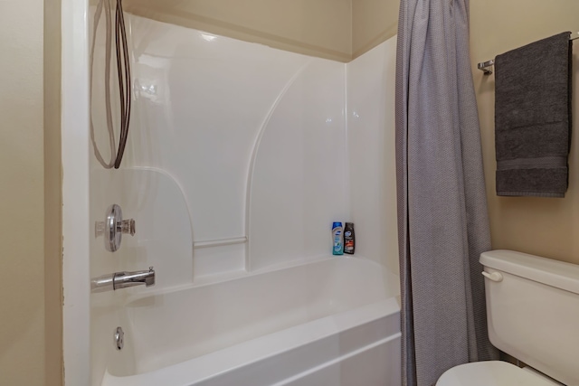 bathroom featuring shower / tub combo with curtain and toilet