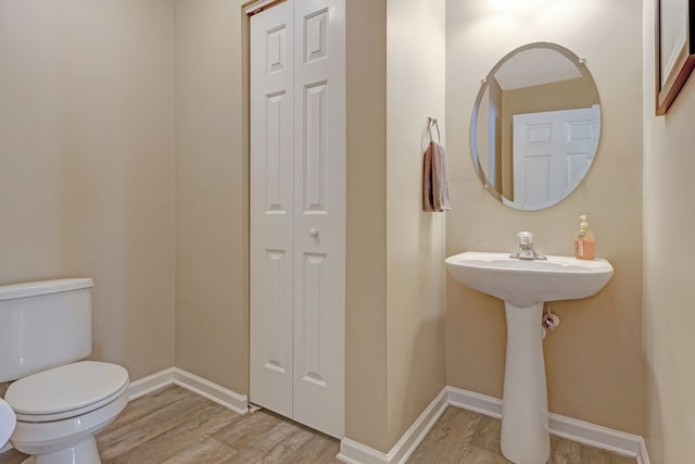 bathroom with hardwood / wood-style floors and toilet