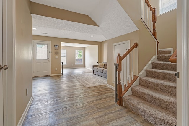 foyer entrance with wood-type flooring and a textured ceiling