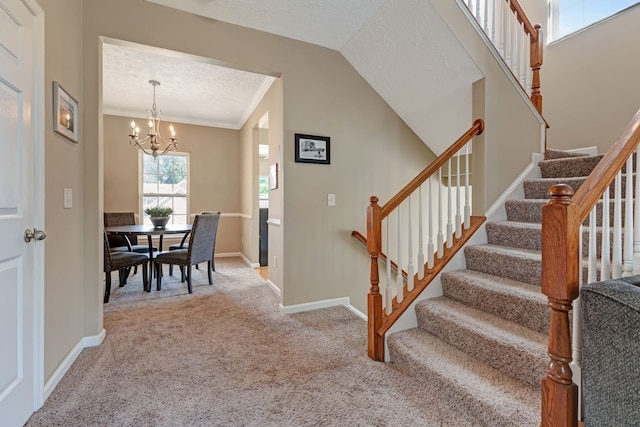 staircase with crown molding, carpet floors, a notable chandelier, and a textured ceiling