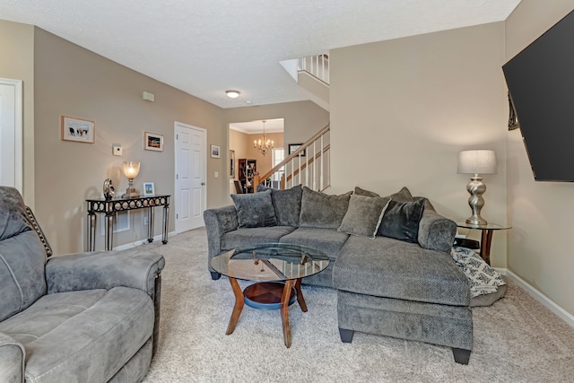 carpeted living room featuring a notable chandelier and a textured ceiling