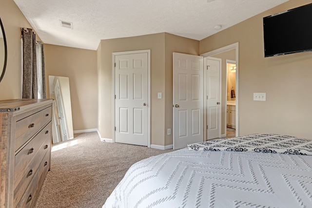 bedroom featuring light carpet and a textured ceiling