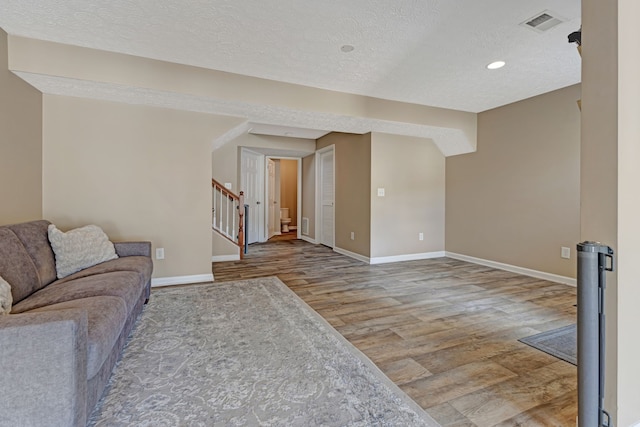 living room with hardwood / wood-style flooring and a textured ceiling