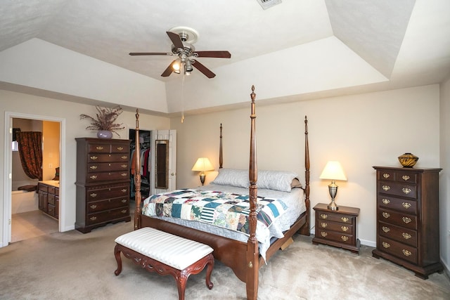 carpeted bedroom featuring connected bathroom, a closet, vaulted ceiling, and ceiling fan