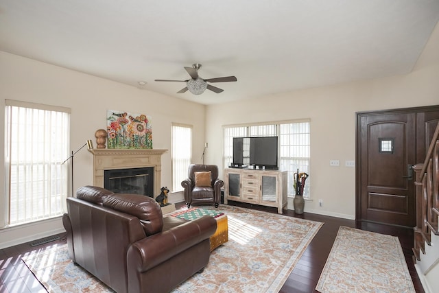 living room featuring ceiling fan, a wealth of natural light, and dark hardwood / wood-style floors