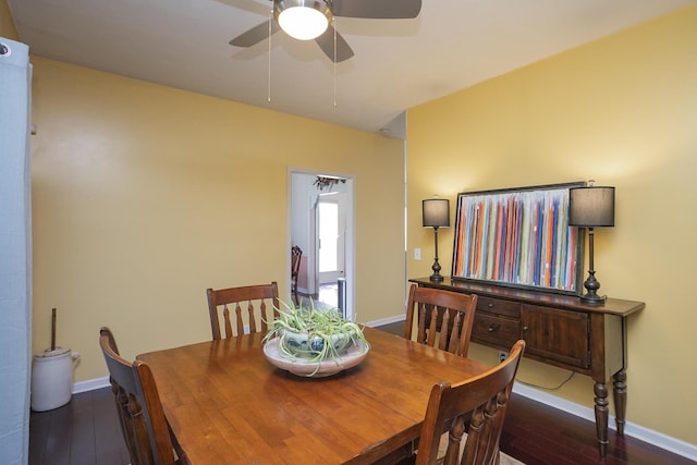 dining space with ceiling fan and dark hardwood / wood-style flooring