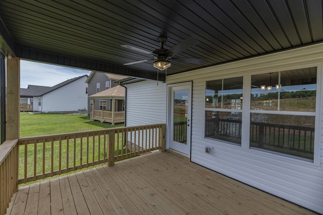 wooden deck with a yard and ceiling fan