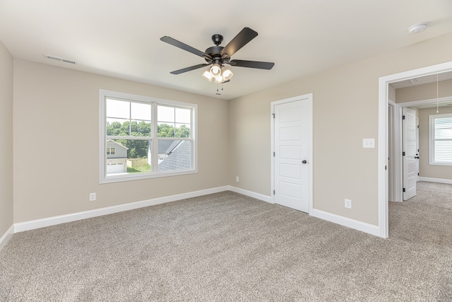 unfurnished bedroom featuring light colored carpet, ceiling fan, and a closet