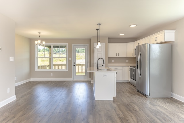 kitchen with a center island with sink, appliances with stainless steel finishes, sink, white cabinetry, and hardwood / wood-style flooring