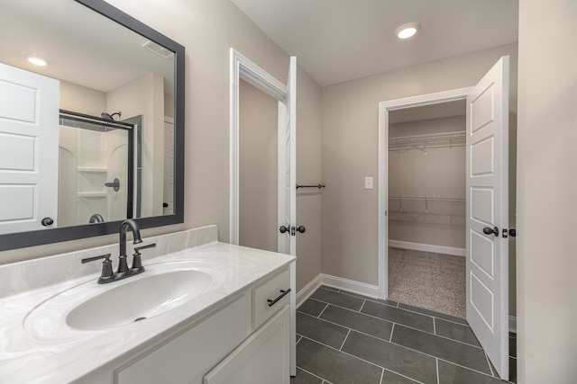 bathroom featuring vanity, a shower with shower door, and tile patterned floors