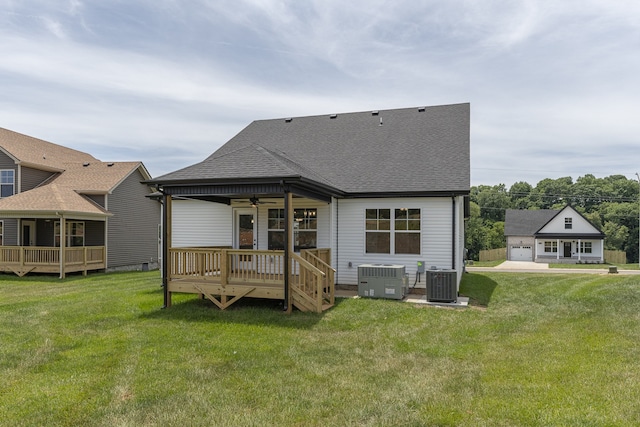 back of house with ceiling fan, central air condition unit, a lawn, and a garage