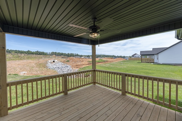 wooden terrace featuring a lawn and ceiling fan