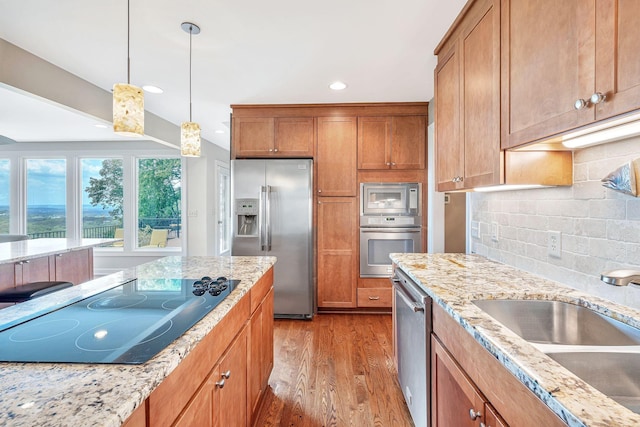 5053 Villa Crest Dr, Nashville, TN 37220 - kitchen featuring appliances with stainless steel finishes, light wood-type flooring, tasteful backsplash, light stone counters, and recessed lighting