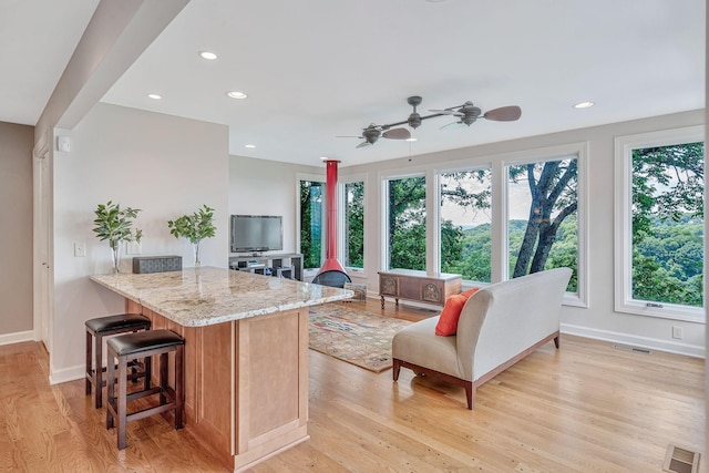 5053 Villa Crest Dr, Nashville, TN 37220 - kitchen featuring ceiling fan, light stone counters, a kitchen breakfast bar, light wood-style flooring, and recessed lighting