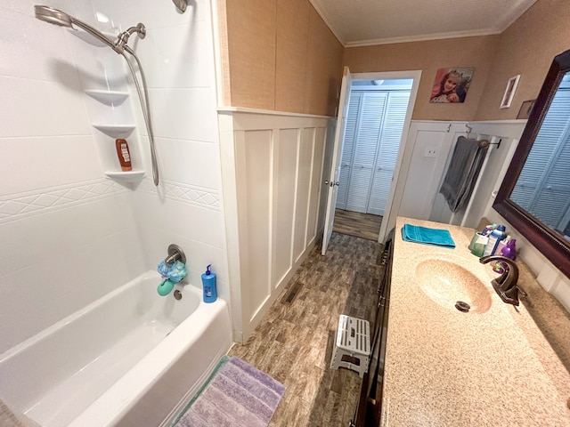 bathroom with hardwood / wood-style floors, shower / bath combination, crown molding, and vanity